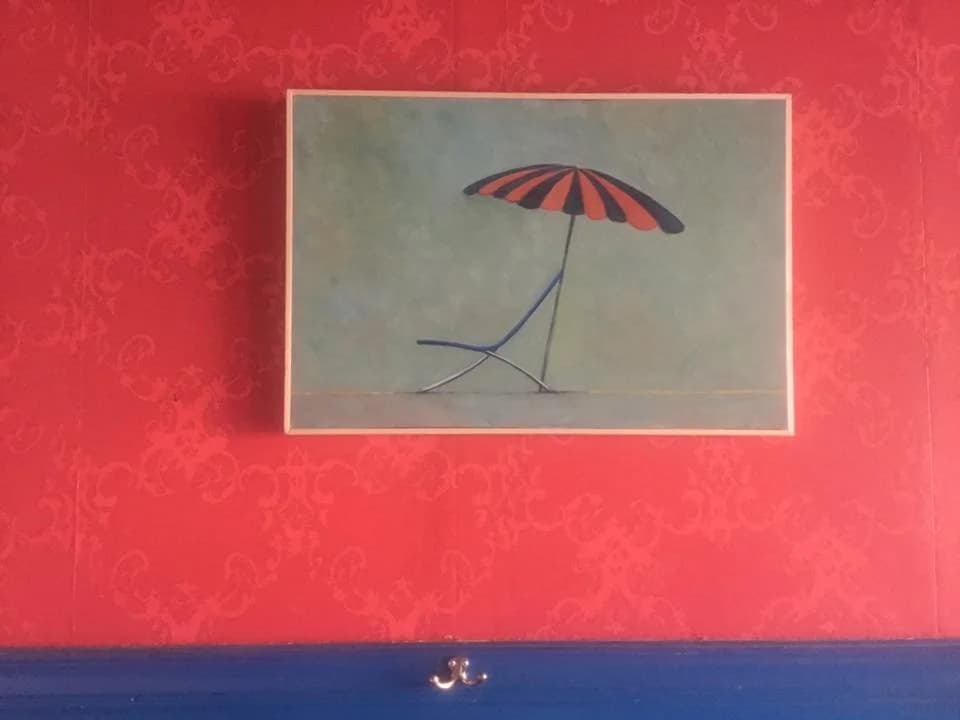 Schilderij met roze-zwarte parasol aan de wand